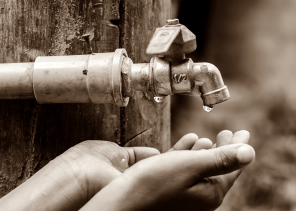 Imagem ilustrativa mostra mãos debaixo de torneira vazia.